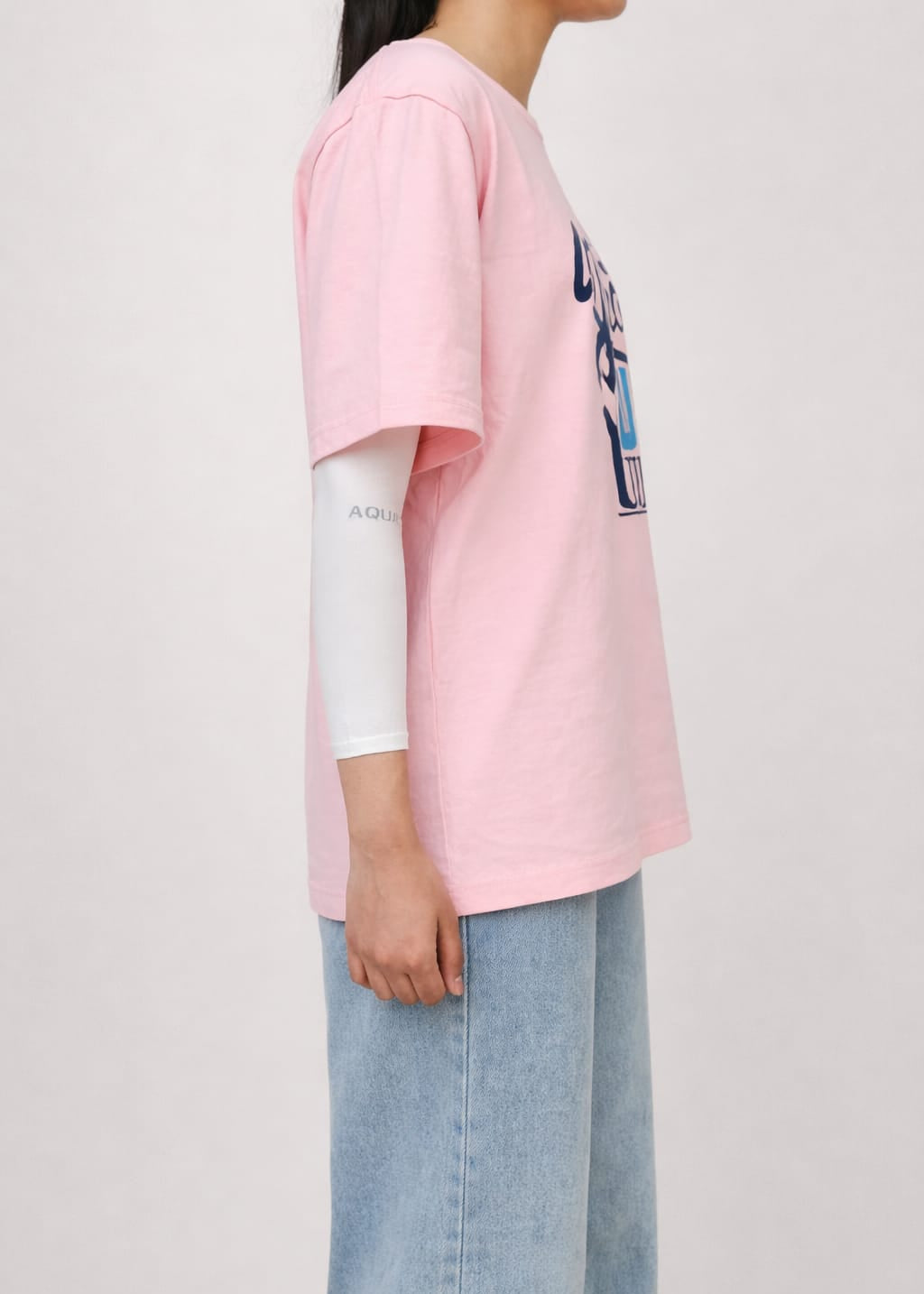 Model wearing pink graphic t-shirt with “What's Up Dudes” print in a relaxed casual streetwear style by NUR