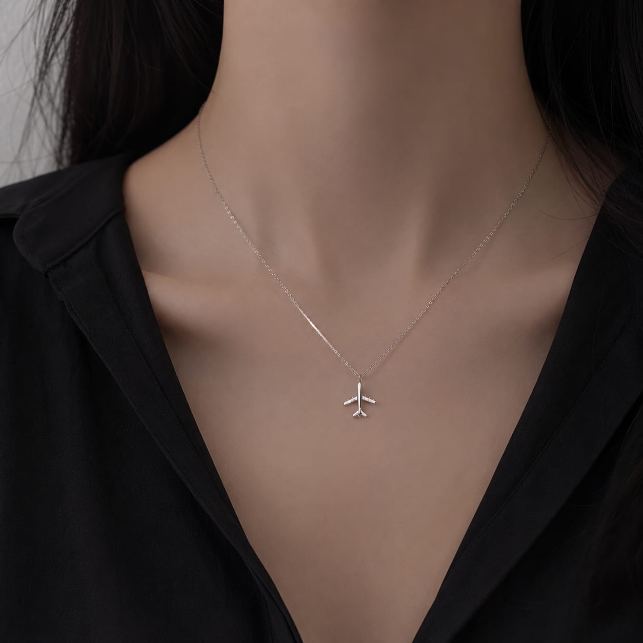 Minimal airplane pendant necklace in silver finish symbolizing travel and adventure stylish everyday jewelry
