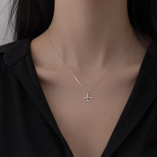 Close up of airplane pendant necklace delicate chain perfect gift for travel lovers and aviation enthusiasts