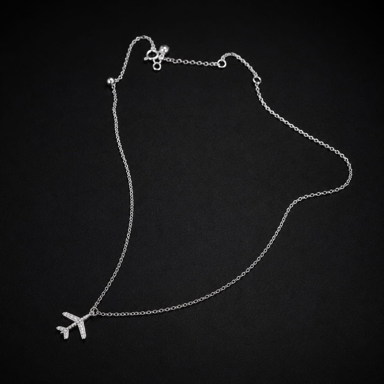 Minimal airplane pendant necklace in silver finish symbolizing travel and adventure stylish everyday jewelry