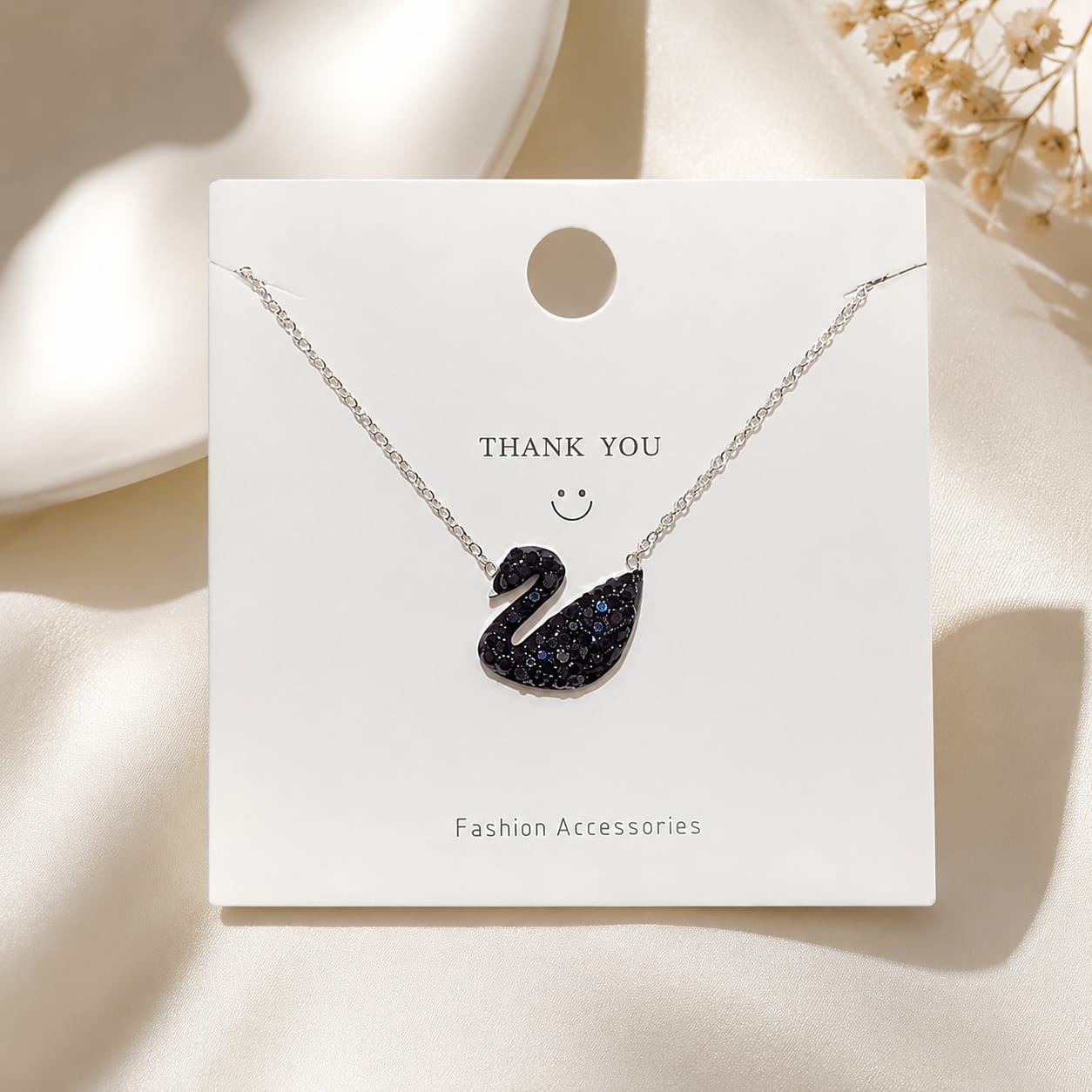 Black swan crystal necklace with delicate chain and elegant sparkling pendant on neutral background