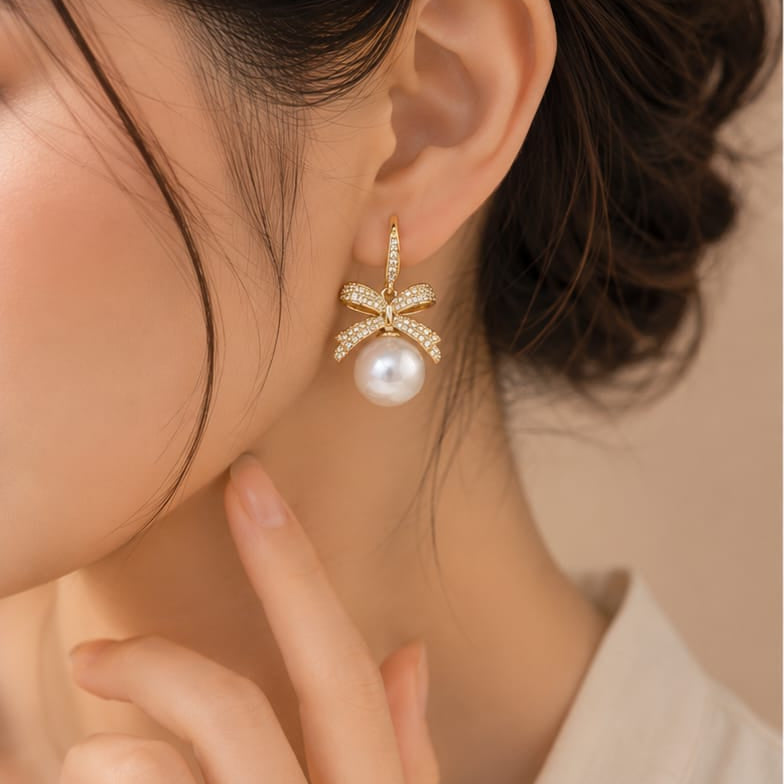 close up of crystal bow pearl earrings showing intricate bow shape with pearl drop and crystal detailing