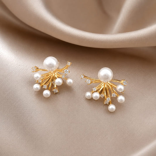 close up of pearl sunburst stud earrings showing gold detailing and pearl center