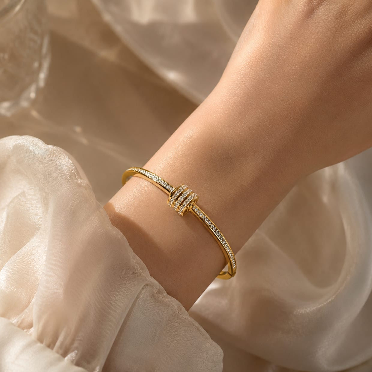 gold crystal accent bangle with white stones and polished finish on minimal background