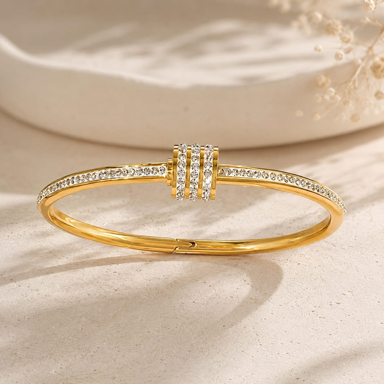 close up of gold bangle showing white crystal accents and smooth polished surface