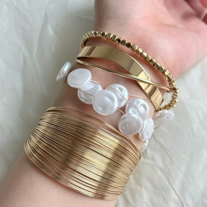 gold layered wire cuff bangle styled on wrist highlighting bold yet minimal design