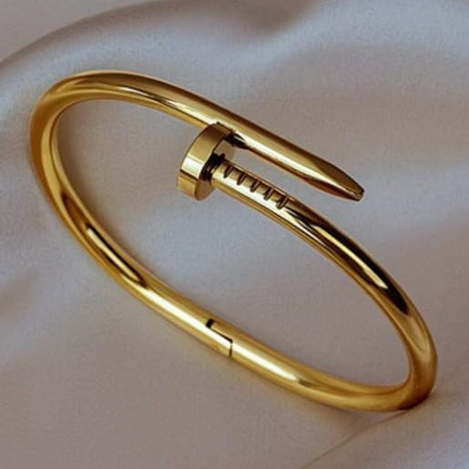 gold nail hand cuff bracelet wrapped around wrist with sleek minimal design on clean background