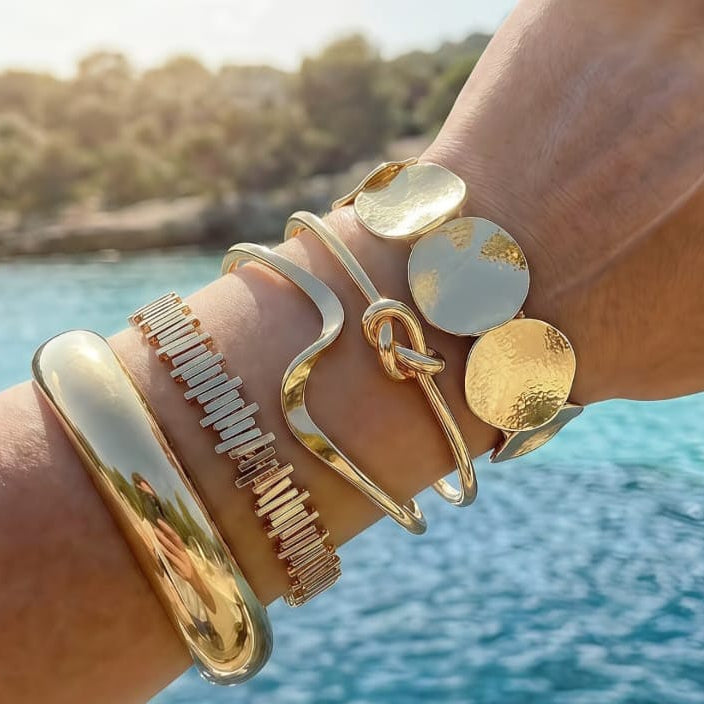 close up of gold organic statement cuff bangle showing unique curved shape and smooth texture