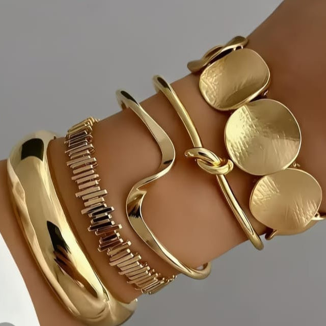 gold organic cuff bangle with fluid sculptural design and polished finish on minimal background