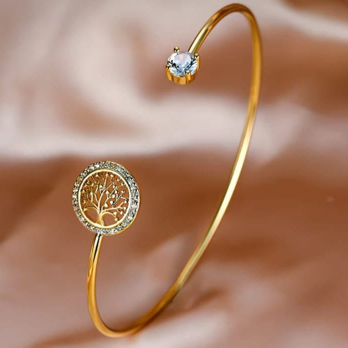 gold tree of life crystal cuff bracelet with intricate design and sparkling stones on clean background