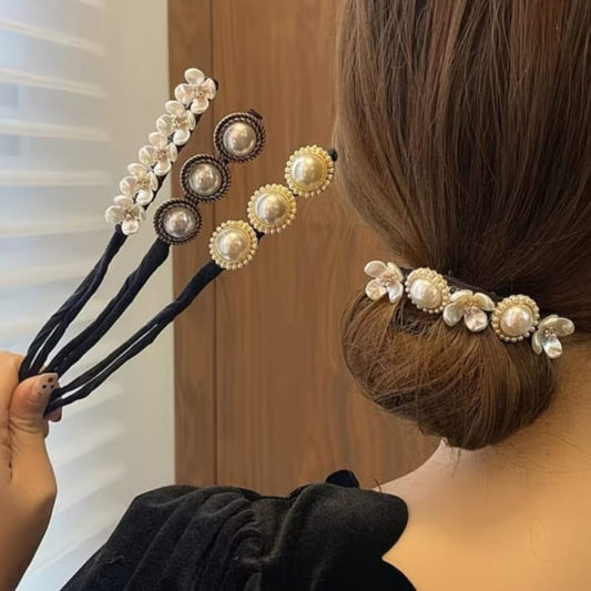 Three black hair accessory clips decorated with faux pearls and floral details, shown being held by a hand and worn in a woman's low bun.