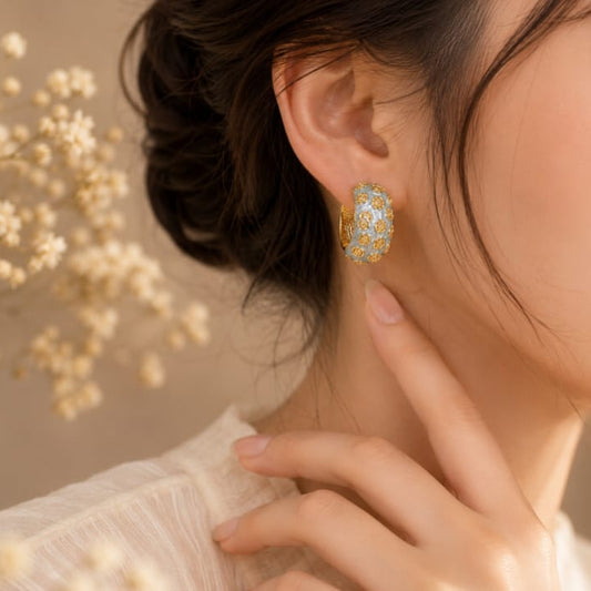 close up of vintage rose hoop earrings showing intricate rose pattern with antique inspired finish