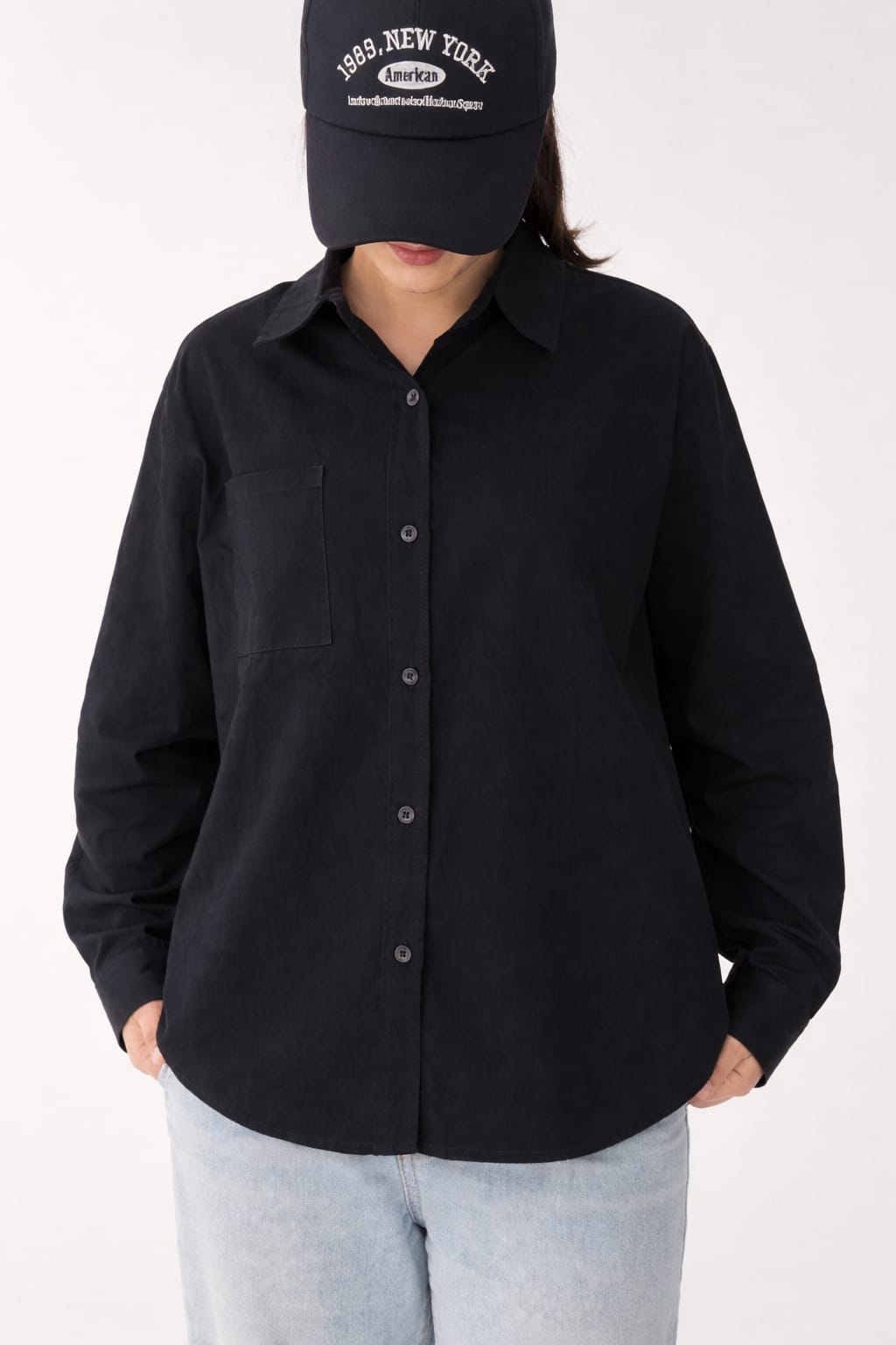 Model wearing black 100% cotton button-down shirt with a clean minimal modern style by NUR, suitable for smart casual and formal wear