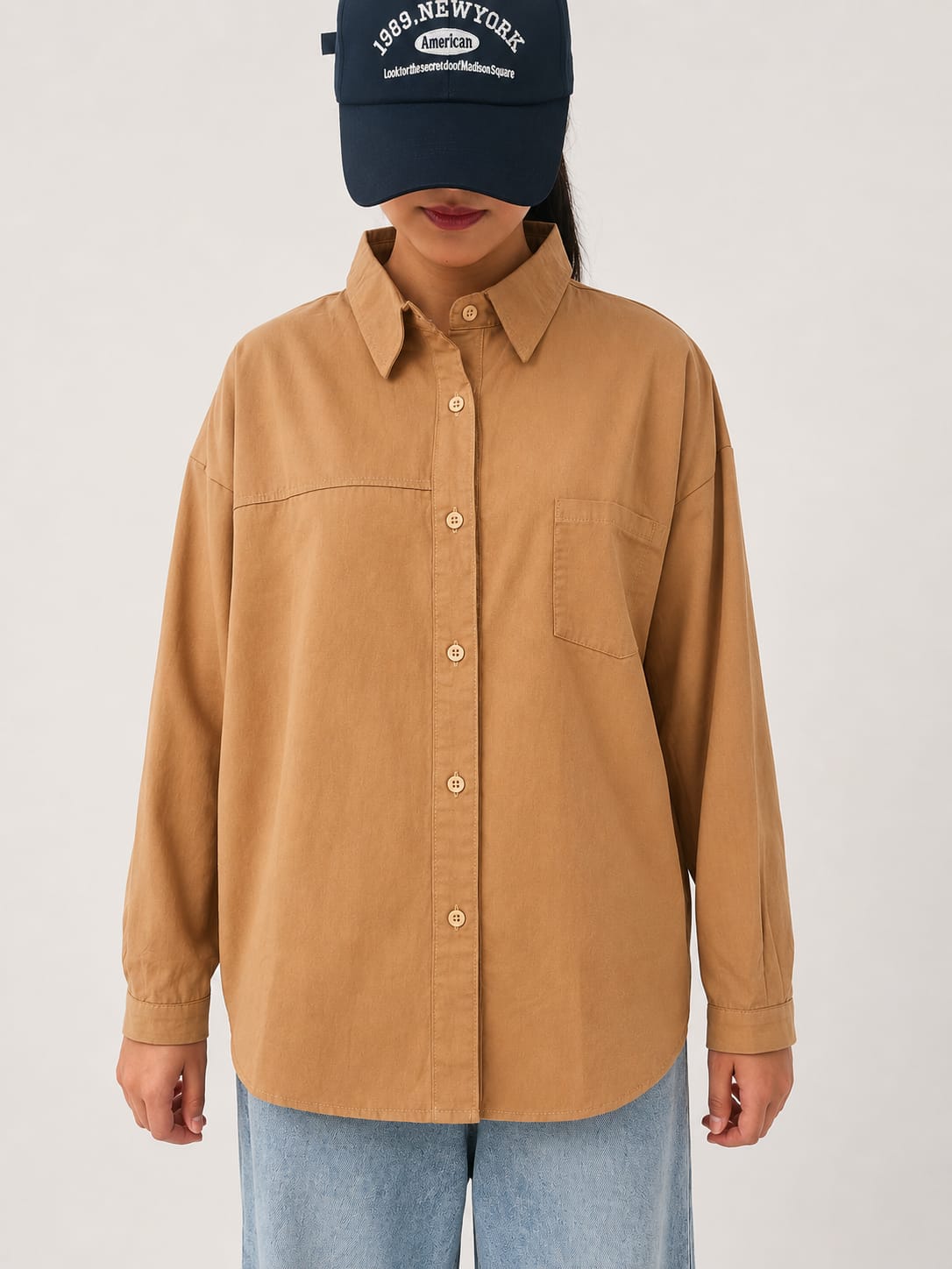 Model wearing brown 100% cotton button-down shirt with a clean minimal style by NUR, perfect for smart casual and everyday wear