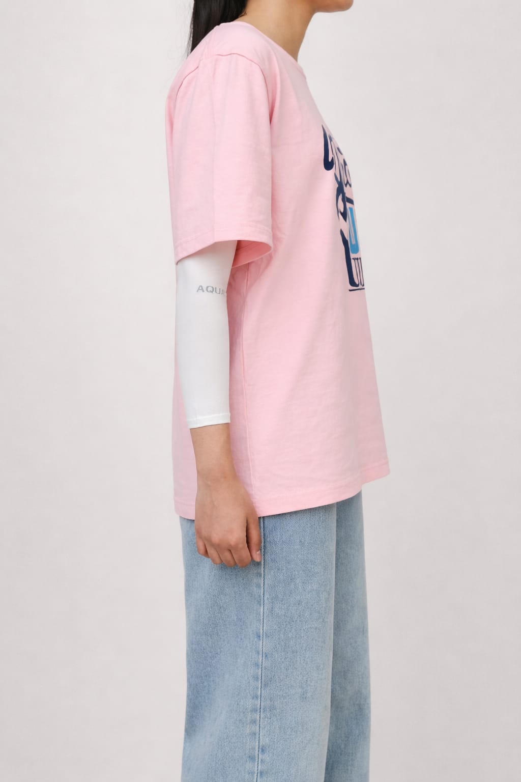 Model wearing pink graphic t-shirt with “What's Up Dudes” print in a relaxed casual streetwear style by NUR